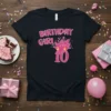 Birthday Girl 10 text design with pink glitter graphics and candles on a black t-shirt