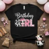 Birthday Girl text with a cute cow face and floral accents on a black t-shirt, perfect for a birthday party
