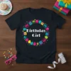 Birthday Girl text on a black t-shirt surrounded by colorful birthday gifts, balloons, and stars
