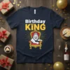 Birthday KING t-shirt design with a white text 'Birthday' and yellow text 'KING' above a lion wearing a crown on