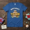 Birthday To Me To text with festive birthday cake graphic on a blue t-shirt