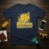 Navy t-shirt with "Bitcoin Millionaire" text and Bitcoin logo graphic, showing upward arrows and circuit board pattern