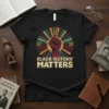 Black t-shirt with "BLACK HISTORY MATTERS" text, a raised fist, and a sunburst graphic with cultural patterns