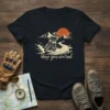 T-shirt with "blaze your own trail" text and a graphic of a motorcyclist riding on a mountain road at sunset