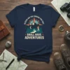 Blessed Are The Curious For They Shall Have Adventures quote on a navy t-shirt with a mountain, compass, and hiker