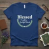 Blessed with a Grateful Heart quote on a navy t-shirt with laurel wreath graphic and arrow detail