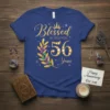 Blessed by God for 56 Years t-shirt with gold glitter text and crown graphic, featuring a jeweled laurel wreath around