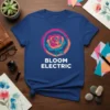 Bloom Electric text below a geometric rose graphic in a circular brush stroke frame, on a royal blue t-shirt