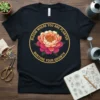 Bloom Where You Are Planted Nurture Your Growth quote on a dark t-shirt with a pink and orange peony graphic