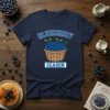 Blueberry Season t-shirt featuring a woven basket overflowing with ripe blueberries and green leaves, with "BLUEBERRY" arched above and "SEASON"