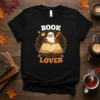 Book Lover text with a cute ghost reading a book graphic on a black t-shirt, perfect for bookworms