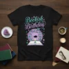 Bookish Birthday t-shirt with whimsical typography, a cozy armchair, cat, open book, and bookshelves graphic