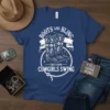 Boots and Bling That's How Cowgirls Swing text design with cowboy boots and rope graphic on a navy t-shirt