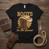 Boots On The Ground text with cowboy boots and hat graphic on a black t-shirt