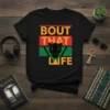 Black t-shirt with "Bout That Life" text and a black panther graphic in Pan-African colors