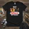 Boy By Day Ninja By Night t-shirt design featuring a silhouette of a child running with a sword and a