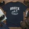 Breck Colorado Mountains graphic t-shirt design featuring a stylized mountain range and sun, text reads "BRECK COLORADO"