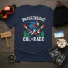 Breckenridge Colorado text with a skier mid-air, snow-covered mountains, and pine trees graphic on a navy t-shirt