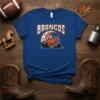 Broncos text above a running horse with mountains and moon graphic on a blue t-shirt
