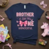 Navy blue t-shirt with pink text: BROTHER of Little Miss ONE WONDERFUL, featuring a large pink bow and small butterflies