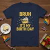 Bruh It's My Birth Day text with a cartoon cake wearing sunglasses and a party hat, on a navy t-shirt
