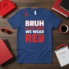 Blue t-shirt with bold white and red text that reads "BRUH IN OCTOBER WE WEAR RED," featuring red awareness ribbons