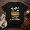 Buffet ALWAYS FINDS ME quote on a black t-shirt with a graphic of a festive buffet table laden with food