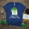 Blue t-shirt with "Bump's First St. Patrick's Day" text and a calendar graphic showing March 17, featuring baby footprints within