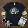 Black t-shirt with white text BUSY DILLY DALLYING, featuring stars and decorative swirls