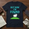 Christian T-Shirt with "But Now I'm Found" text and a graphic of a sheep on a hill