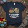 T-shirt featuring the quote "Buying Yarn And Using It Are Two Different Hobbies Hobbies" with illustrations of yarn baskets and