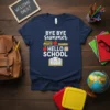 Bye Bye Summer Hello School text design with school bus, apples, ruler, and open book graphic on a navy t-shirt