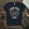 Cabin Crew 2026 t-shirt design featuring a cozy cabin in a forest under a starry night sky with a crescent