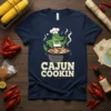 Cajun Cookin t-shirt design with a cartoon alligator chef stirring a pot of food