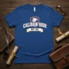 Caliban High Est. 1611 text on a blue t-shirt with a shield logo featuring a griffin