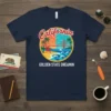 California Golden State Dreamin t-shirt with a circular beach design featuring the Golden Gate Bridge, palm trees, and ocean waves