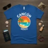 Cancún México text with a vibrant beach sunset graphic, palm tree, and sailboat on a blue t-shirt