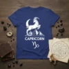 Capricorn zodiac sign graphic with a leaping goat, moon, and mountains on a navy blue t-shirt. Includes the word CAPRICORN