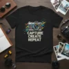 Black t-shirt with "CAPTURE CREATE REPEAT" text and a stylized camera graphic, perfect for photography enthusiasts