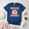 T-shirt design with text "CARING FOR tiny little SWEETHEARTS" and cute baby sheep, bear, and bunny held in pink fabric