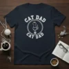 Cat Dad Cat Dad text design with a crowned cat silhouette and paw print, featured on a navy blue t-shirt