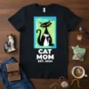 Black t-shirt with white text "CAT MOM EST. 2024" and a graphic of two cats in a retro style