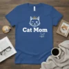 Blue t-shirt with white text "Cat Mom" and a winking cat wearing a crown graphic