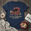 Cats Are Connosseurs Of Comfort t-shirt design featuring a black cat sleeping in a chair with a blanket and books