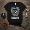 Black t-shirt with "Cats Rule The Underworld" text and a gothic cat skull graphic featuring multiple cat faces