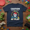 Caution Childish Adult At Play t-shirt design with a skull wearing a beanie and holding controllers, surrounded by building blocks