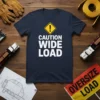 Navy blue t-shirt with white text "CAUTION WIDE LOAD" and a yellow warning sign graphic