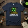 Navy blue t-shirt with a radioactive symbol and "CAUTION: YOU MIGHT GET ADDICTED TO ME" text in white and yellow