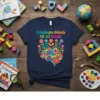 Celebrate Minds Of All Kinds text with colorful brain and floral graphic on navy blue t-shirt