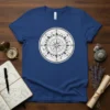Circular celestial compass rose design with stars and geometric patterns on a blue t-shirt